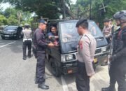 Dikawal Brimob Bersenjata, Polisi Pasang Bendera Merah Putih pada Kendaraan Warga yang Melintas