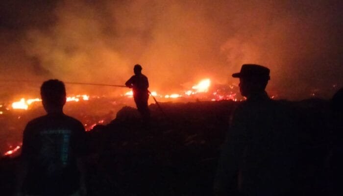 Tumpukan Kayu Sisa Banjir Terbakar, Babinsa dan Warga Bahu-Membahu Padamkan Api
